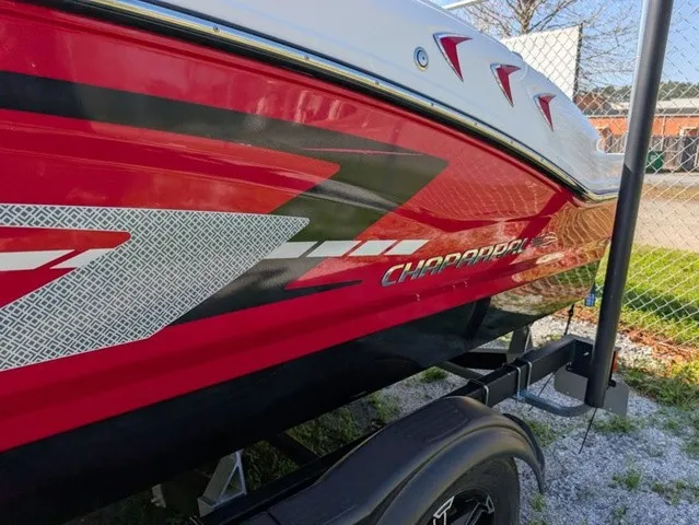 Slide: The Image of Red Chaparral 21 SSi boat from 2023 on a trailer, featuring stylish graphics on the side. - 10