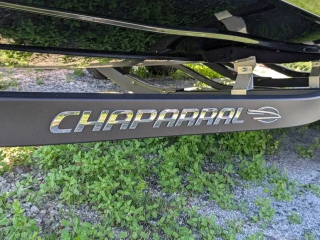 Slide: The Image of Close-up of the Chaparral logo on a boat trailer, surrounded by grass. - 3