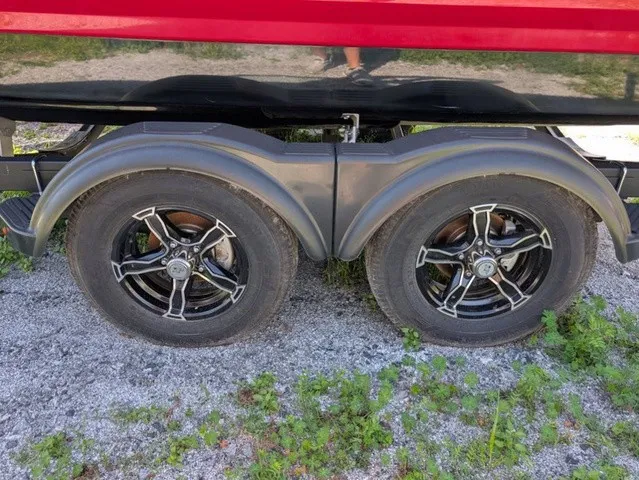Slide: The Image of Close-up of a boat trailer with two black wheels on a gravel path. - 11
