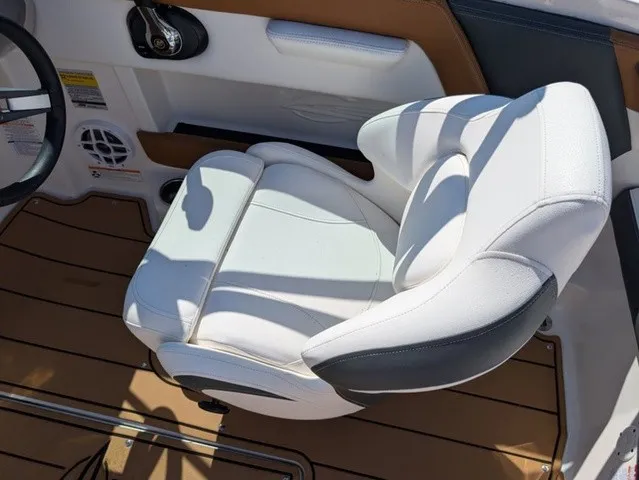 Slide: The Image of A white cushioned boat seat with brown accents on a 2023 Chaparral 21 SSi. - 21