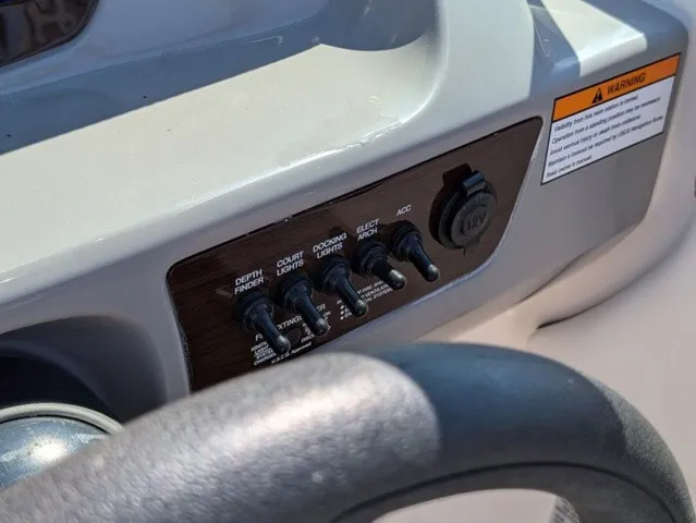 Slide: The Image of Close-up of a Chaparral 21 SSi helm with switches and a warning label. - 27