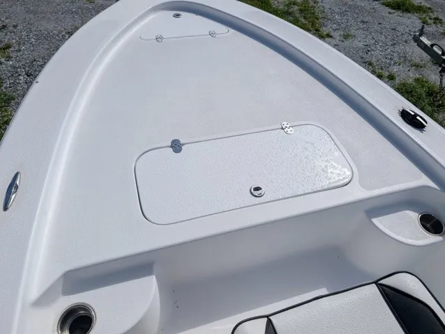 Slide: The Image of The image shows the deck of a white boat with a storage hatch and cup holders. - 28