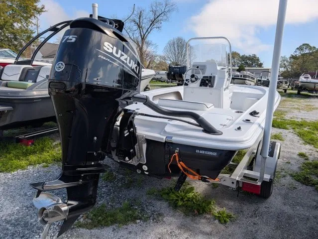 Slide: The Image of A white motorboat with a Suzuki engine is on a trailer in an outdoor area. - 14