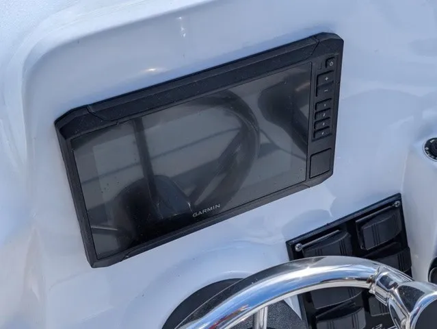 Slide: The Image of A modern helm with a large Garmin display and a shiny steering wheel. - 24