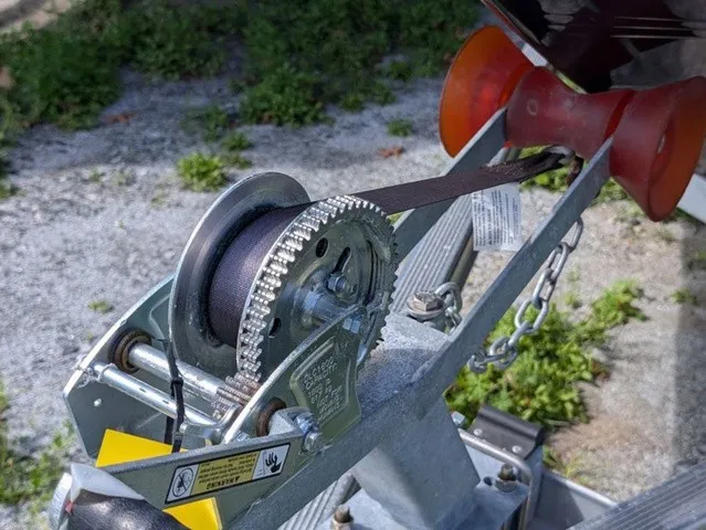 Slide: The Image of Close-up of a boat winch on a trailer with a strap and chain. - 5