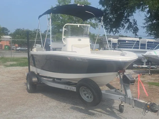 Slide: The Image of A 2016 Robalo R160 Center Console boat on a trailer, featuring a blue Bimini top. - 4