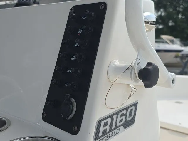 Slide: The Image of Close-up of the control panel on a 2016 Robalo R160 Center Console boat with switches. - 14