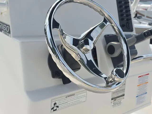 Slide: The Image of Close-up of the shiny steering wheel on a 2016 Robalo R160 Center Console boat. - 21