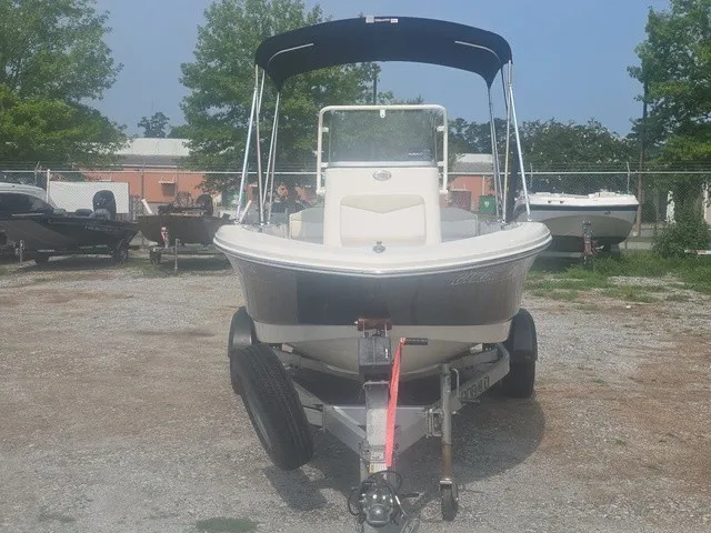 Slide: The Image of A 2016 Robalo R160 Center Console boat on a trailer, featuring a black bimini top. - 3