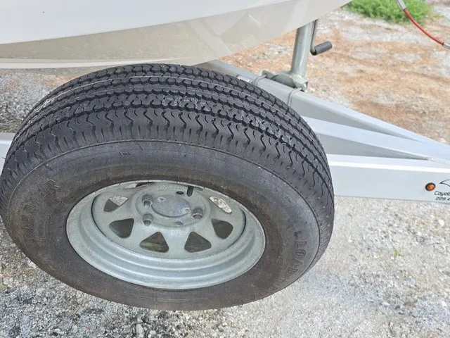 Slide: The Image of Close-up of a boat trailer wheel on a gravel surface. - 12