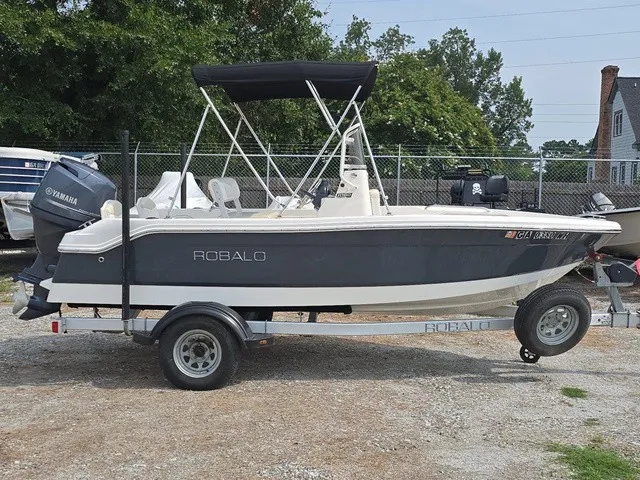 Slide: The Image of A 2016 Robalo R160 Center Console boat on a trailer, featuring a Yamaha outboard motor. - 5