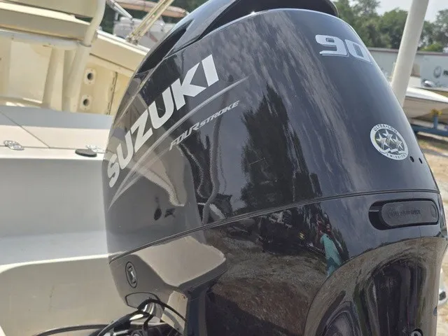 Slide: The Image of A Suzuki 90 HP outboard motor is mounted on a boat. Other boats are visible in the background. - 16