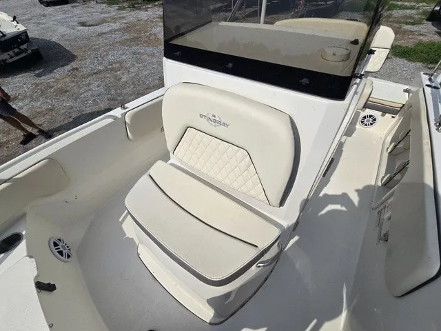 Slide: The Image of The image shows the cockpit of a 2023 Stingray 173 CC boat with beige upholstery. - 32