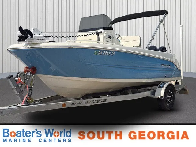 The Image of A blue and white 2023 Stingray 173 CC boat on a trailer in a showroom. - 1