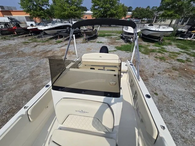 Slide: The Image of A 2023 Stingray 173 CC boat with an open deck and black sunshade. - 33