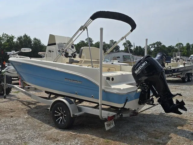 Slide: The Image of A blue and white 2023 Stingray 173 CC boat on a trailer with a Suzuki outboard motor. - 4