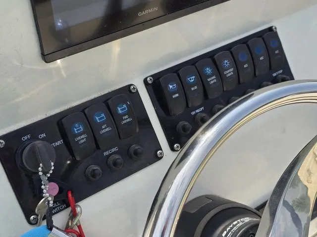 Slide: The Image of Close-up of a boat's helm with switches and a steering wheel. - 22