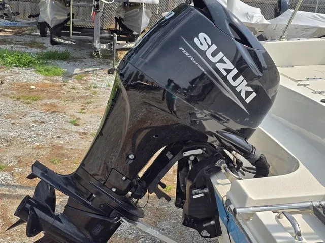 Slide: The Image of A Suzuki outboard motor is attached to a boat on dry, gravelly ground. - 13