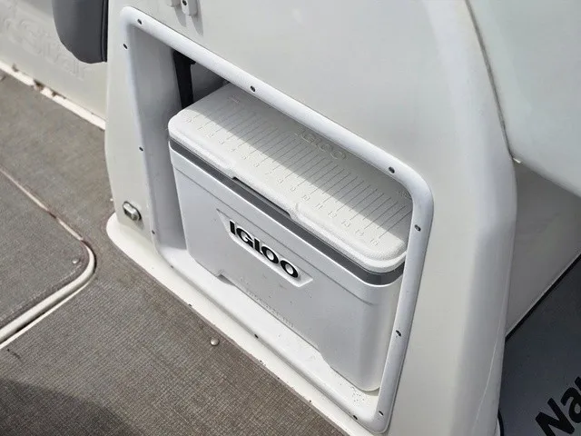 Slide: The Image of A built-in Igloo cooler in a NauticStar 243 DC boat, surrounded by gray carpeting. - 21