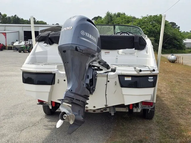 Slide: The Image of A white boat with a Yamaha outboard motor is parked on a lot. It has an open rear. - 5