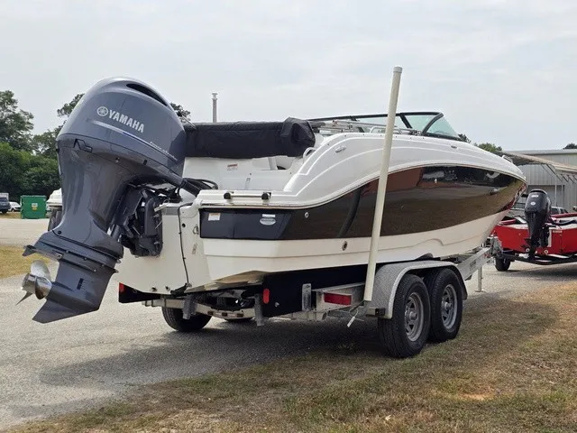 Slide: The Image of A white 2022 NauticStar 243 DC boat on a trailer with a Yamaha outboard motor. - 6