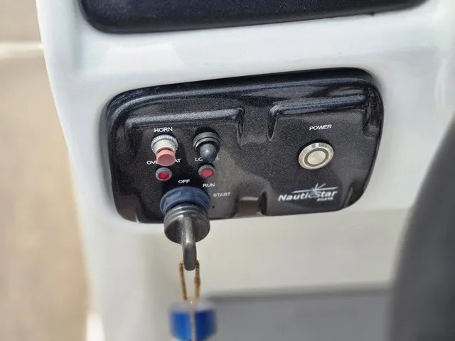 Slide: The Image of Close-up of a control panel with key switch and buttons on a NauticStar boat. - 23