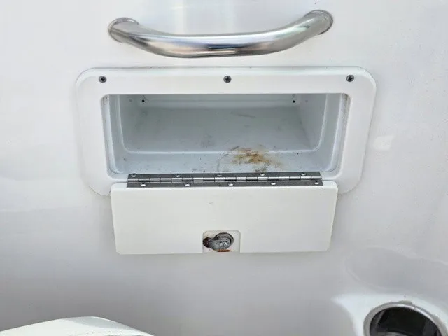 Slide: The Image of A white storage compartment with a handle and lock on a boat. - 30