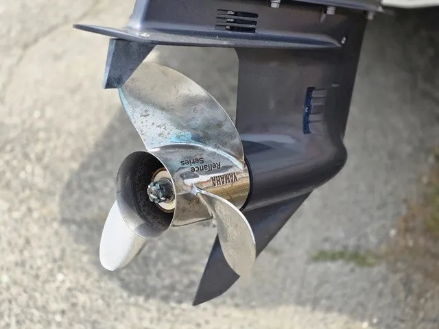 Slide: The Image of A shiny propeller on an outboard motor, mounted on a boat, on a dry surface. - 33