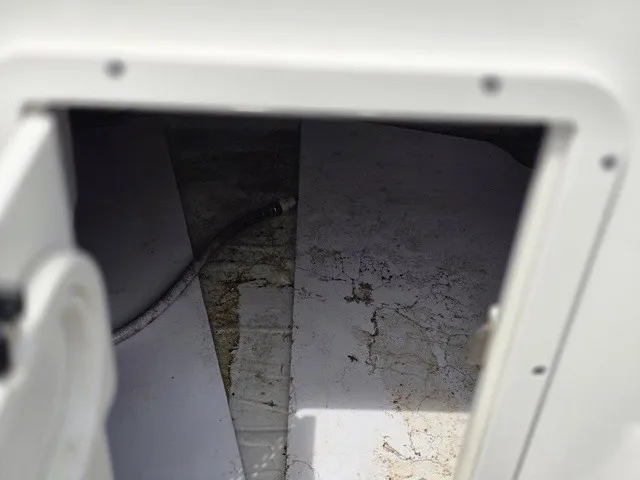 Slide: The Image of An open storage compartment on a boat with a hose inside. - 28