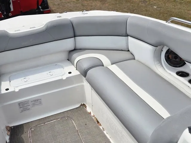 Slide: The Image of The image shows the gray and white cushioned seating area at the stern of a NauticStar 243 DC boat. - 12
