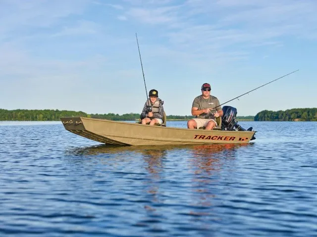 The Image of Two people fishing in a Tracker Grizzly® 12 Jon boat on a calm lake. - 1