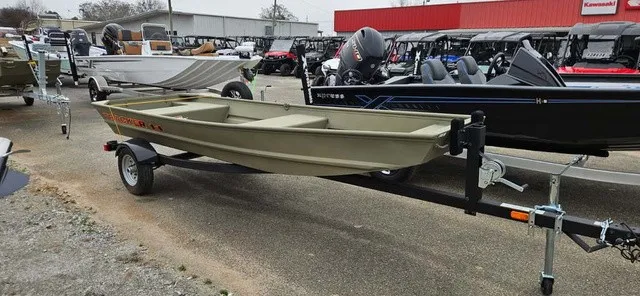 The Image of A 2025 Tracker Grizzly 1436 Utility boat on a trailer, surrounded by other boats and vehicles. - 1