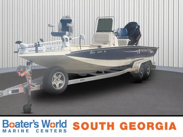 The Image of A 2012 Xpress H22B Bay boat on a trailer in a showroom setting. - 1