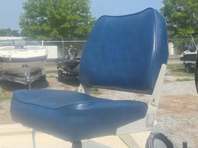 Slide: The Image of A blue boat seat with a white frame, mounted outdoors on a boat. - 13