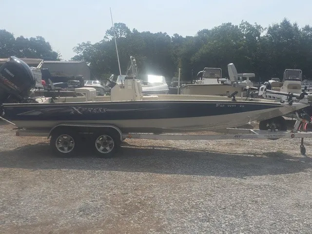 Slide: The Image of A 2012 Xpress H22B Bay boat on a trailer, surrounded by other boats. - 5
