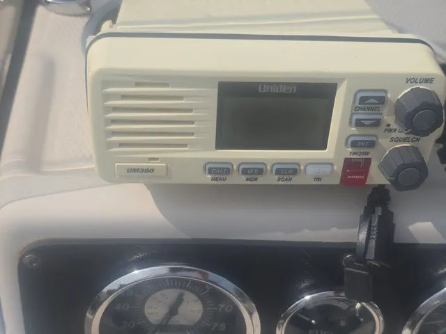 Slide: The Image of A Uniden VHF radio is mounted on a boat's dashboard, surrounded by gauges. - 18