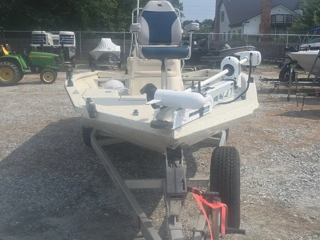 Slide: The Image of A 2012 Xpress H22B Bay boat on a trailer, featuring a seat and motor at the front. - 3