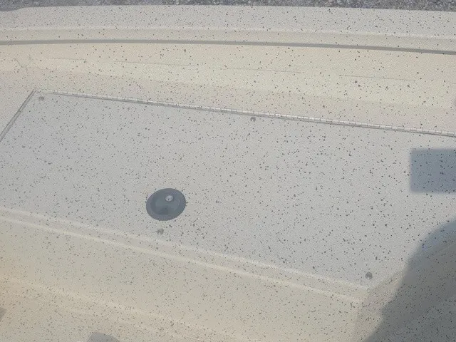 Slide: The Image of Close-up of a boat deck with a round hatch and speckled surface. - 25