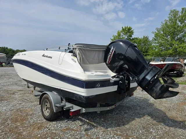 Slide: The Image of A 2021 Hurricane SunDeck Sport 192 RL OB boat on a trailer in a gravel lot. - 6