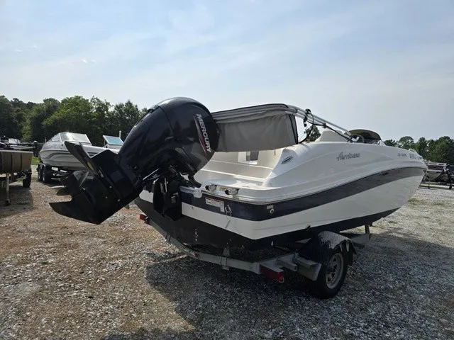Slide: The Image of A white 2021 Hurricane SunDeck Sport 192 RL OB boat on a trailer in a gravel lot. - 5