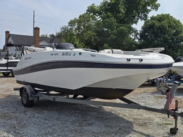 Slide: The Image of A white 2021 Hurricane SunDeck Sport 192 RL OB boat on a trailer in a gravel lot. - 3