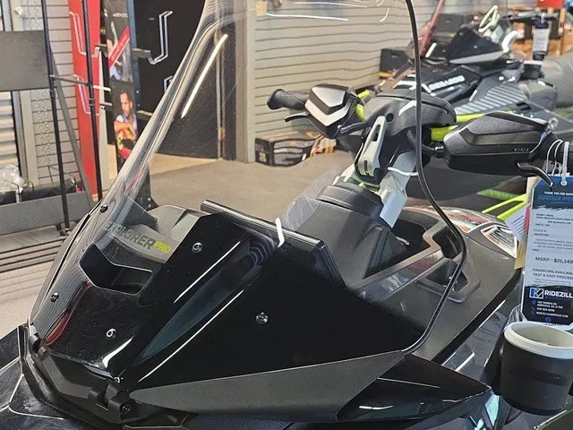 Slide: The Image of A Sea-Doo Explorer Pro 2026 with a tall windshield and modern dashboard in a showroom. - 17