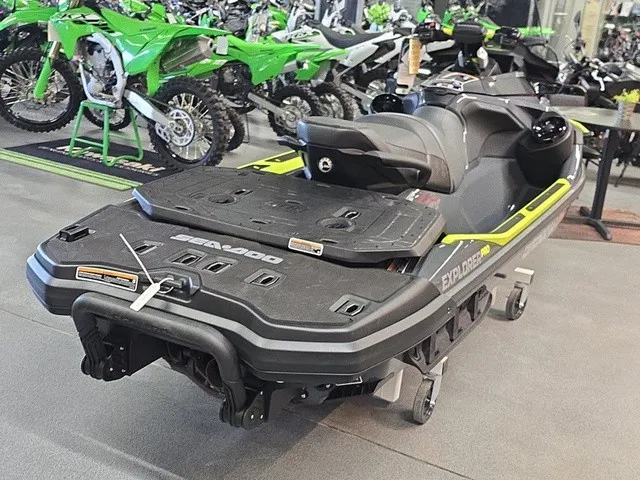 Slide: The Image of A Sea-Doo Explorer Pro 2026 jet ski is in a showroom, surrounded by other vehicles. - 6
