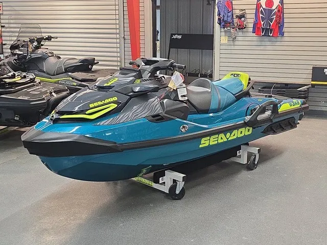Slide: The Image of A 2026 Sea-Doo Wake Pro 230 jet ski is displayed in a showroom on a rolling cart. - 2