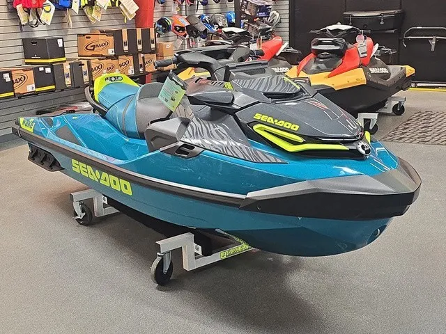 Slide: The Image of A blue and black Sea-Doo Wake Pro 230 jet ski is displayed on a dolly in a showroom. - 4