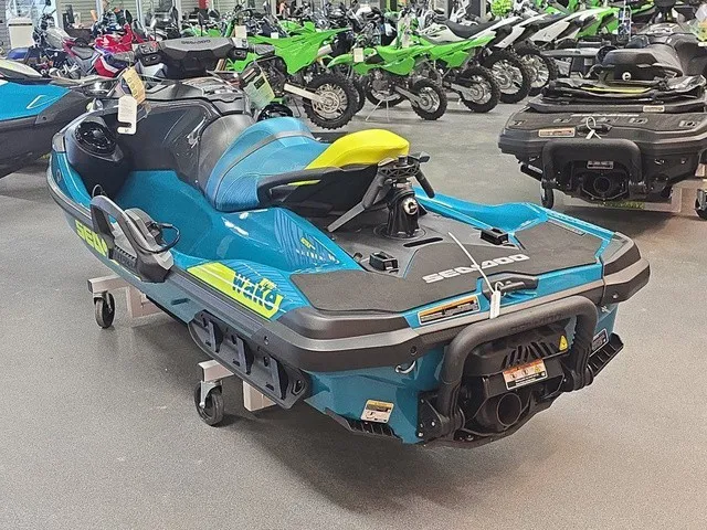 Slide: The Image of A blue and yellow Sea-Doo Wake Pro 230 jet ski is in a showroom, surrounded by other vehicles. - 8