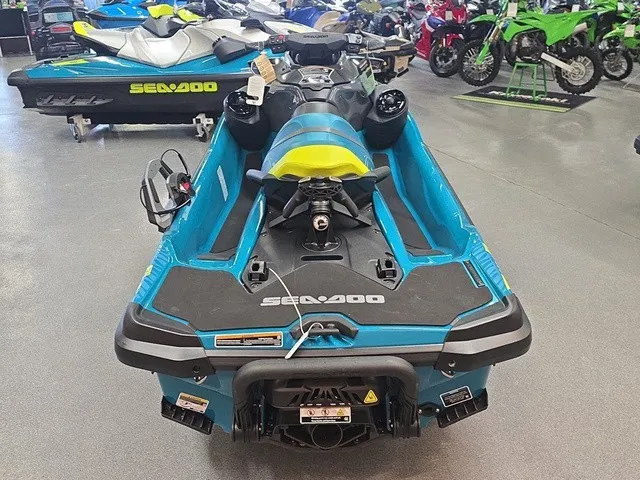 Slide: The Image of A blue Sea-Doo Wake Pro 230 jet ski is in a showroom, surrounded by other vehicles. - 7