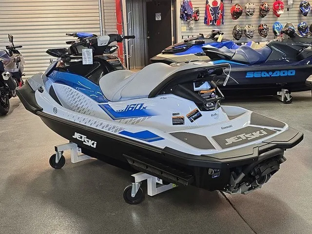 Slide: The Image of A 2026 Kawasaki Jet Ski STX is displayed in a showroom. It features a sleek blue and white design. - 9