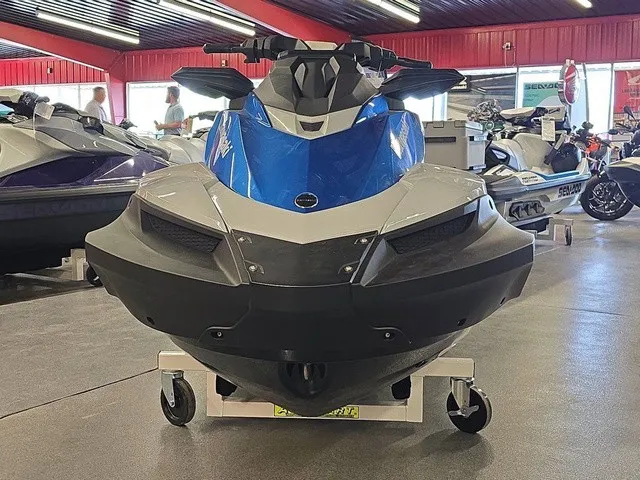 Slide: The Image of A blue 2026 Kawasaki Jet Ski STX is displayed on a dolly in a showroom. - 3