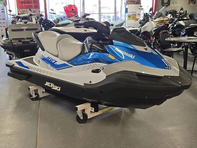 Slide: The Image of A blue 2026 Kawasaki Jet Ski STX is displayed in a showroom on a rolling stand. - 4